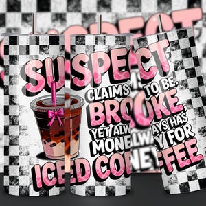 May include: A white tumbler with a black and white checkered pattern. The tumbler has a pink and white graphic that says "SUSPECT CLAIMS TO BE BROOKE, YET ALWAYS HAS MONEY FOR ICED COFFEE". The graphic also includes a cartoon image of a cup of iced coffee with a pink bow.