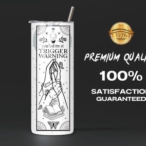 May include: White stainless steel tumbler with a black and white design featuring two hands holding a book with the text "you had me at TRIGGER WARNING".