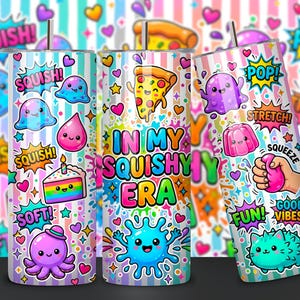 May include: Three cylindrical tumblers with metal straws featuring a colorful pattern of cartoon squishy toys, pizza, cake, and hearts on a light blue and white striped background. The text "IN MY SQUISHY ERA" is printed in bold, multi-colored letters.