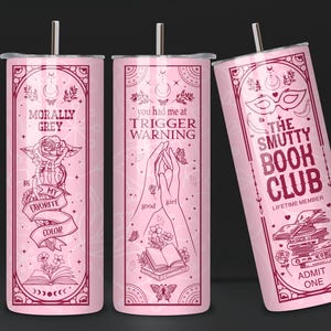 May include: Three pink stainless steel tumblers with different designs. The first tumbler has the text "Morally Grey is my favorite color" with a rose and a book. The second tumbler has the text "You had me at Trigger Warning" with a hand and a book. The third tumbler has the text "The Smutty Book Club Lifetime Member" with a mask, a book stack, and the text "Admit One".