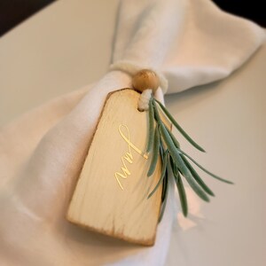 Cartão de lugar - etiqueta creme de madeira de ação de graças de casamento com nome dourado personalizado, vegetação e gravata creme suave