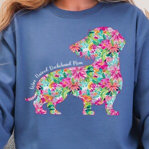 May include: A blue sweatshirt with a floral dachshund silhouette and the text "Wire Haired Dachshund Mom".