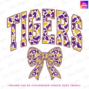 以下が含まれることがあります： 大胆でアーチ型のフォントで「TIGERS」という単語が描かれたグラフィックデザイン。文字は黄色で縁取られ、紫と黄色の斑点模様で塗りつぶされています。その下に同じ模様のリボンがあります。「COLORS CAN BE CUSTOMIZED」というテキストが一番下にあります。
