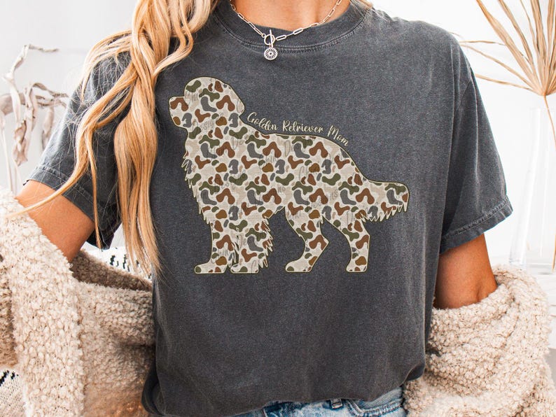 A person wearing a gray t-shirt with a camouflage print of a dog, and a necklace around their neck.