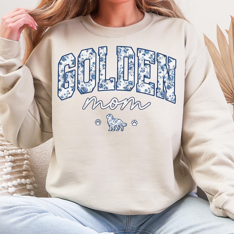 a woman wearing a sweatshirt that says golden mom