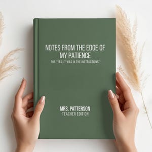 May include: A dark green hardcover notebook with white text that reads: NOTES FROM THE EDGE OF MY PATIENCE, FOR YES, IT WAS IN THE INSTRUCTIONS, MRS. PATTERSON, TEACHER EDITION. The notebook is held by two hands against a plain white background.