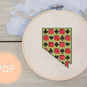 May include: A cross-stitch pattern of the state of Nevada, with a green background and red and black dice and playing card symbols.