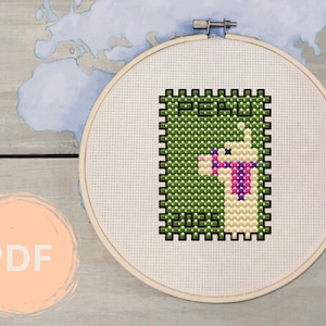 May include: A cross-stitch pattern featuring a llama with a purple scarf and the word "PERU" on a green background. The pattern is framed in a wooden hoop.