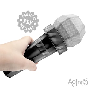 Puede incluir: Un micrófono de papel en blanco y negro sostenido en una mano. El micrófono tiene un diseño geométrico en la cabeza y el cuerpo. Un icono de descarga PDF está en la esquina superior izquierda. El logotipo "Aolmes" está en la esquina inferior derecha.