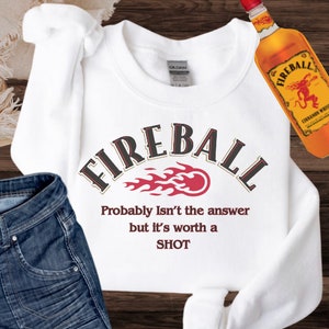 May include: White sweatshirt with a red and black Fireball logo and the text "Probably Isn't the answer but it's worth a SHOT".