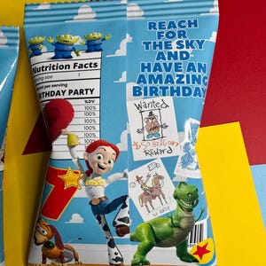 Pode incluir: Um saco de lanches colorido com o tema de festa de anivers&aacute;rio com personagens do filme Toy Story. A sacola tem um fundo de c&eacute;u azul com o texto "Reach for the Sky and Have an Amazing Birthday". A sacola tamb&eacute;m apresenta desenhos de personagens e um r&oacute;tulo de informa&ccedil;&otilde;es nutricionais.