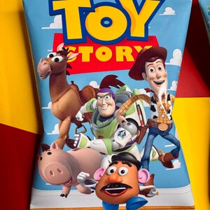 Pode incluir: Uma embalagem azul com as palavras "TOY STORY" em letras amarelas. A embalagem apresenta personagens de desenhos animados como Woody, Buzz Lightyear e o Sr. Batata. O fundo &eacute; azul-c&eacute;u com nuvens brancas.