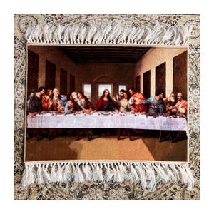 Op de afbeelding: Een wandkleed dat het Laatste Avondmaal voorstelt, een beroemd schilderij van Leonardo da Vinci. Het wandkleed toont Jezus Christus en zijn discipelen die rond een tafel zitten, met een wit tafelkleed en een gedetailleerde achtergrond.