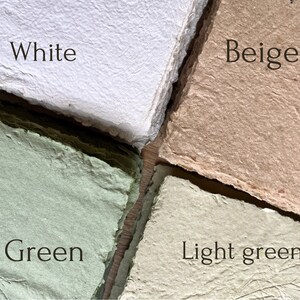 May include: Close-up of four sheets of handmade paper in white, beige, green, and light green. Each sheet has a textured surface and the name of the colour is written on each sheet.