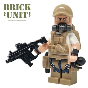 May include: A tan and brown action figure of a soldier, holding a black rifle and a black grenade. The figure wears a tan helmet, a gas mask, and a tactical vest. The text "BRICK UNIT" and "CUSTOM ACTION MINIFIGURES" is visible.