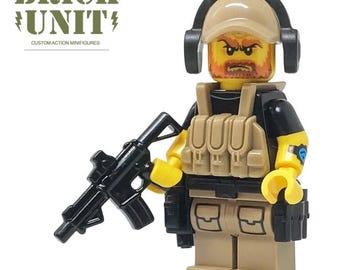 May include: A custom action minifigure from Brick Unit. The figure is a soldier with a tan helmet, headset, and tactical vest. It has a black shirt, tan pants, and a black rifle. The figure has a yellow head with a red beard and angry expression.