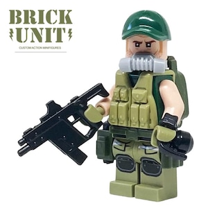 May include: A custom action minifigure from Brick Unit, featuring a military theme. The figure wears a green cap, vest, and pants, with a gas mask and a black rifle. The figure is holding the rifle in its right hand.