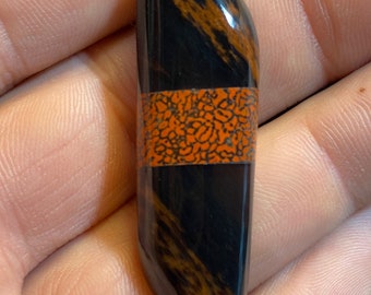 Cabujón con intarsia de obsidiana y gema de dinosaurio y caoba