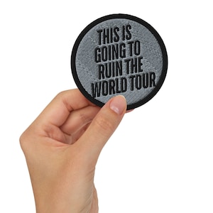 May include: A gray circular patch with black embroidered text that reads "This is going to ruin the world tour."