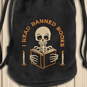 May include: Black drawstring bag with a white skeleton reading a book with the text "I Read Banned Books" in orange.