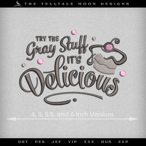 Op de afbeelding: Borduurwerk met de tekst "Try the Gray Stuff It's Delicious" in een grijs handschrift met roze accenten. Het ontwerp bevat een gestileerde cupcake met roze glazuur en een kers op de top. De tekst "4, 5, 5,5 en 6 inch versies" is ook inbegrepen.