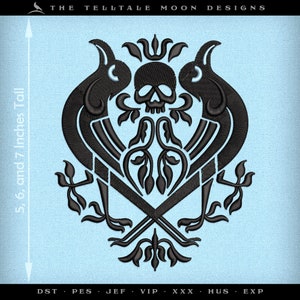 May include: Black embroidered design featuring two stylized birds flanking a skull with a floral motif. The design is 5, 6, and 7 inches tall. The text "THE TELLTALE MOON DESIGNS" appears at the top of the image. The text "DST PES JEF VIP XXX HUS EXP" appears at the bottom of the image.