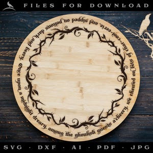 Puede incluir: Una tabla de cortar redonda de madera con un diseño en blanco y negro de una vid con espinas y texto que dice "Once upon a midnight dreary, among the ghoulish guests a'cheery, we chewed on bits of char-cool-eerie, and sipped on potions dark and beery." El texto está en una fuente gótica.