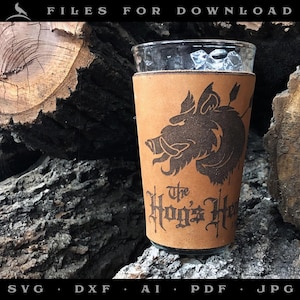 Peut inclure: Un porte-bière en cuir marron avec une illustration en noir et blanc d'une tête de sanglier et le texte "The Hog's Head".