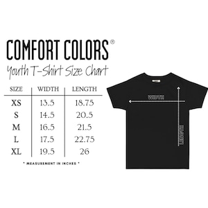 以下が含まれることがあります： 黒色のユースTシャツとサイズチャート。XSからXLまでのサイズが記載されており、幅と長さの測定値はインチです。上部にはComfort Colorsのロゴがあります。