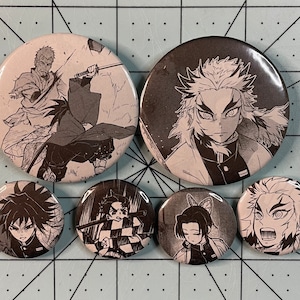 May include: Set of seven round black and white anime character buttons. The buttons feature characters from the anime series Demon Slayer.