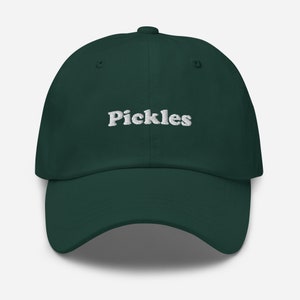 Op de afbeelding: Een donkergroene baseballpet met het woord "Pickles" in wit geborduurd op de voorkant.