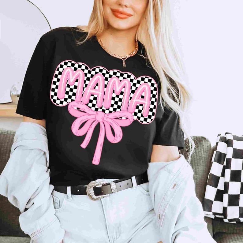 May include: Black t-shirt with a pink "MAMA" graphic in a checkered pattern with a pink bow.