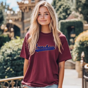 May include: A maroon t-shirt with a blue and yellow vintage-style graphic that says "Grenshaw".