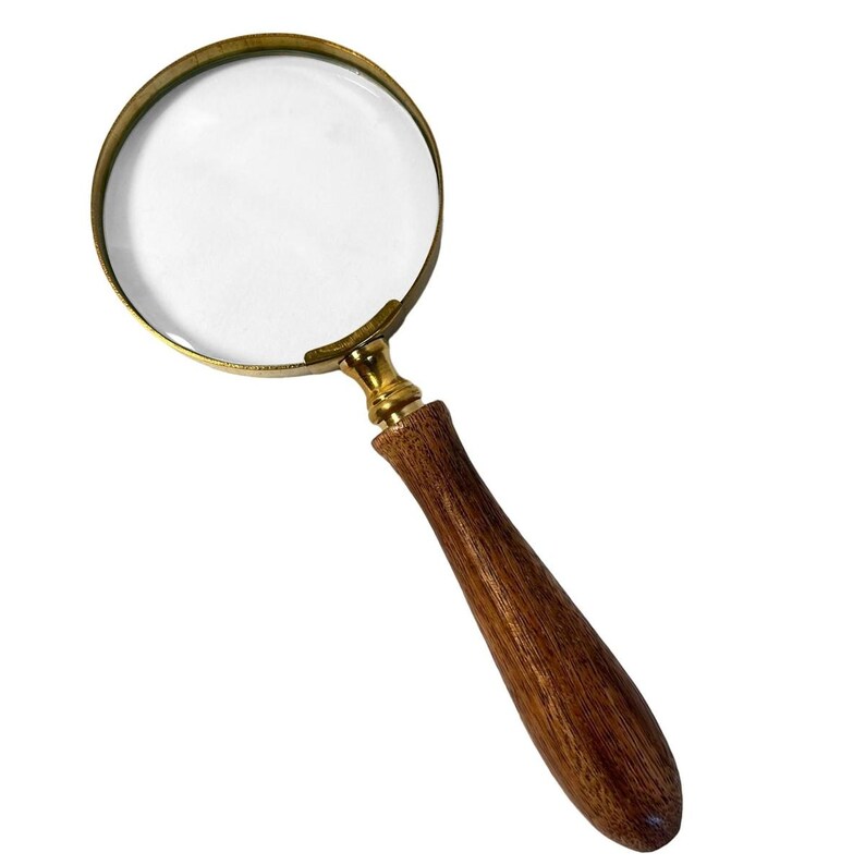 May include: A magnifying glass with a clear lens and a brass-colored frame. The handle is made of polished wood. The magnifying glass is designed for reading or examining small objects.