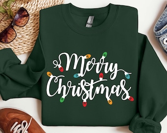 May include: A dark green sweatshirt with the text "Merry Christmas" in white lettering. The text is surrounded by colorful light bulbs.