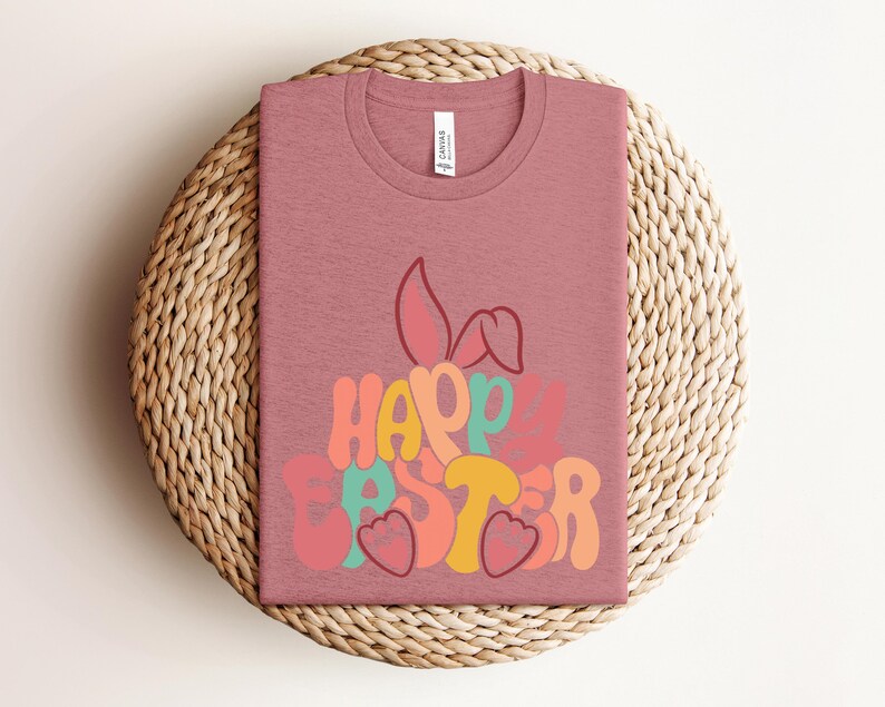 May include: A pink t-shirt with a colorful graphic of a bunny rabbit and the text "Happy Easter".