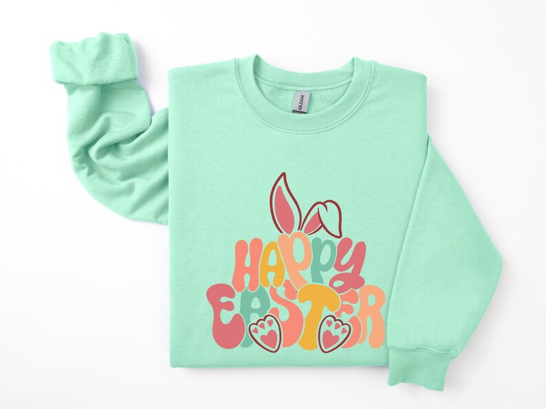 May include: A light green sweatshirt with a colorful "Happy Easter" graphic featuring bunny ears and paw prints.