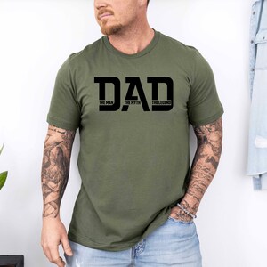 May include: A green t-shirt with a black graphic that says "DAD THE MAN THE MYTH THE LEGEND".