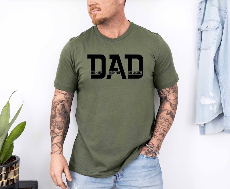 May include: A green t-shirt with a black graphic that says "DAD THE MAN THE MYTH THE LEGEND".