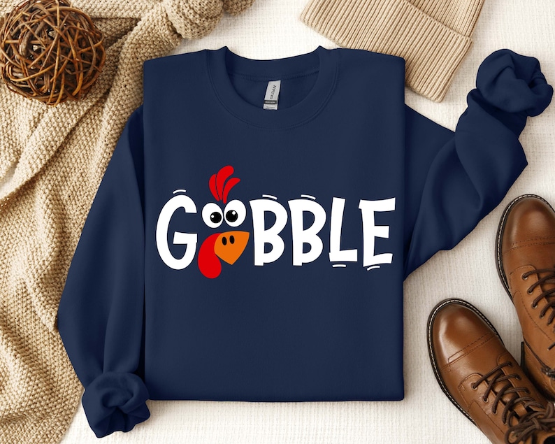 May include: A navy blue sweatshirt with a white graphic of a turkey head and the word "GOBBLE".