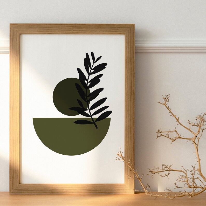 May include: A framed print with a minimalist design featuring a black silhouette of a leaf and two green circles on a white background.