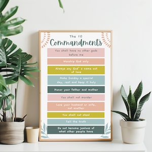 Peut inclure: Une impression encadrée avec le texte "Les 10 Commandements" dans une police décorative. L'impression présente un design coloré avec les dix commandements listés verticalement.