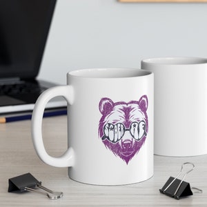 May include: White ceramic mug with a purple bear wearing heart-shaped sunglasses that say "Sober AF".