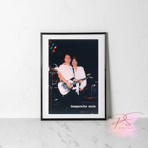 Puede incluir: Fotografía enmarcada de una pareja, el hombre sostiene una guitarra eléctrica blanca. La imagen está ambientada sobre un fondo oscuro, con luces de escenario visibles. El texto "Inseparable souls" está impreso en la parte inferior.