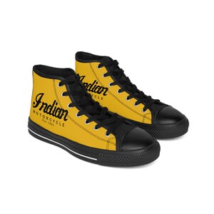 May include: Yellow high-top canvas sneakers with black laces and a black toe cap. The shoes feature a black and white logo that says "Indian Motorcycle Est. 1901".