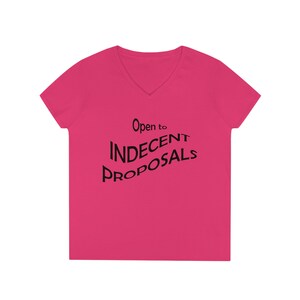 Puede incluir: Una camiseta rosa de cuello en V con el texto "Open to INDECENT PROPOSALS" en negro.