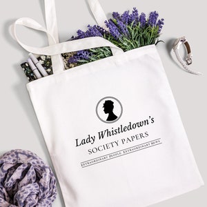 Puede incluir: Bolsa de tela blanca con texto negro y una silueta de cabeza de mujer en un círculo. El texto dice "Lady Whistledown's Society Papers. Extraordinary People. Extraordinary News."