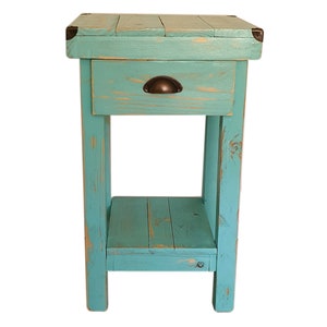 May include: A teal blue wooden end table with a single drawer and a lower shelf. The drawer has a rustic metal handle. The table has a distressed finish.