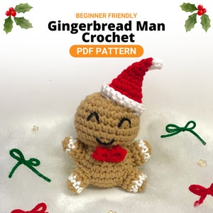 Puede incluir: Un hombre de jengibre tejido a ganchillo con un gorro de Papá Noel y una pajarita rojos. El hombre de jengibre es de color canela con detalles blancos y ojos y boca cosidos en negro. El texto "BEGINNER FRIENDLY Gingerbread Man Crochet PDF PATTERN" está en la parte superior.