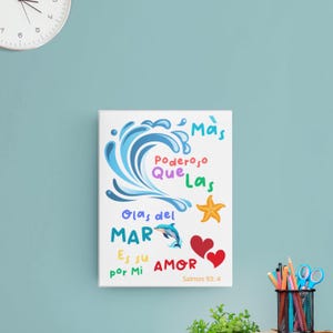 Op de afbeelding: Een witte canvasprint met een blauw golfontwerp en kleurrijke tekst die "Mas Poderoso Que Las Olas del MAR Es su AMOR por Mi Salmos 93:4" luidt.